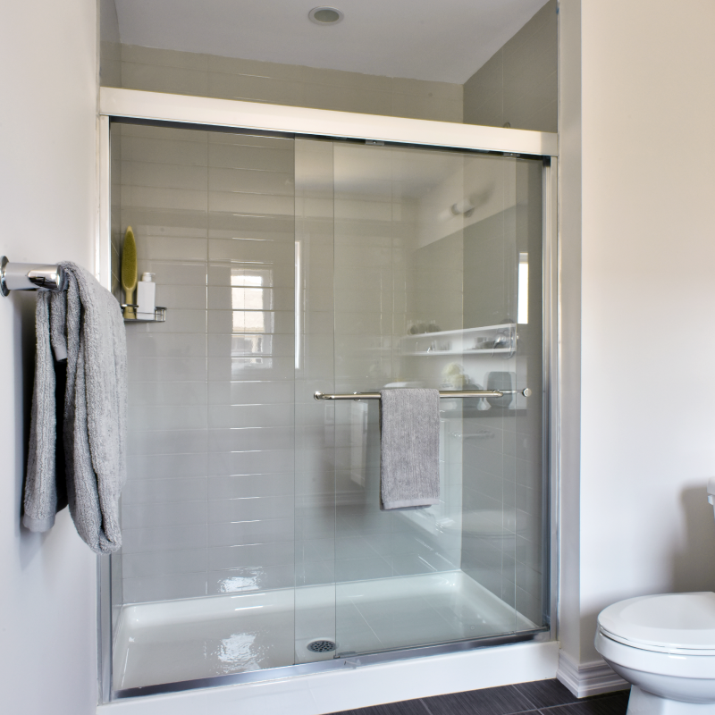 Modern, grey and white, clean bathroom with glass-door bathtub and shower